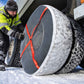 トラックの車輪に取り付けられたAutoSockタイヤソックス、冬の風景の雪の上を運転