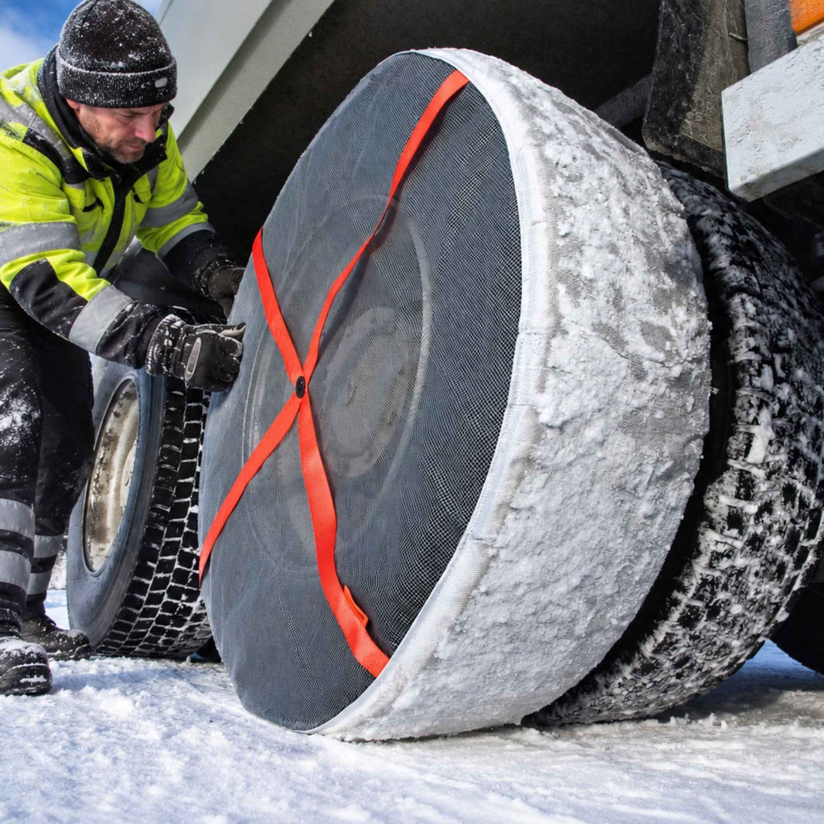トラックの車輪に取り付けられたAutoSockタイヤソックス、冬の風景の雪の上を運転